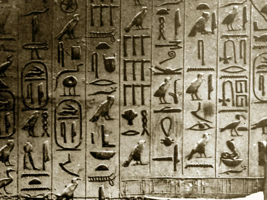 Wall detail from the pyramid of Unas covered with carved Egyptian hieroglyphic Pyramid Texts.