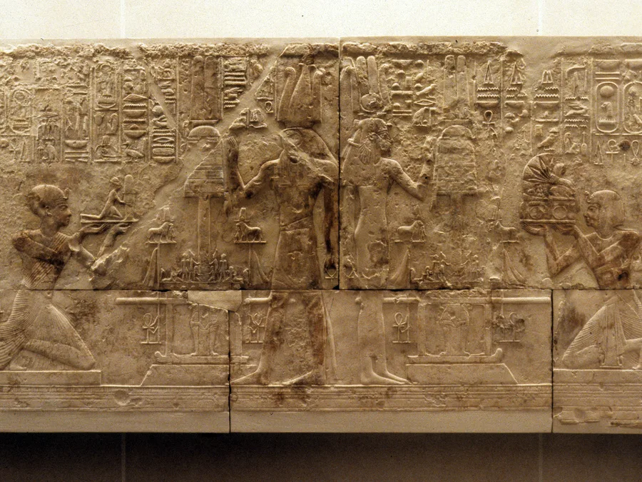 Egyptian chapel relief of Ramesses I before Osiris with offering scenes and hieroglyphic Pyramid Texts-derived spells.